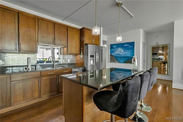 132 Lakefront Blvd Unit 403, Buffalo, NY 14202 - kitchen with a sink, stainless steel appliances, brown cabinets, dark wood-style floors, and decorative backsplash