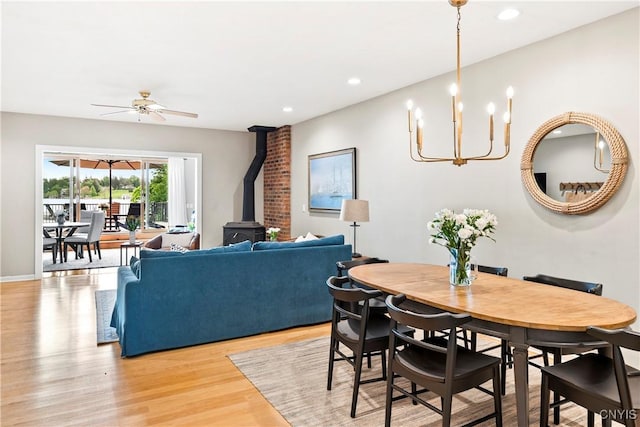 18 E Genesee St Unit 1, Skaneateles, NY 13152 - dining room with a wood stove, ceiling fan, light wood finished floors, recessed lighting, and a chandelier