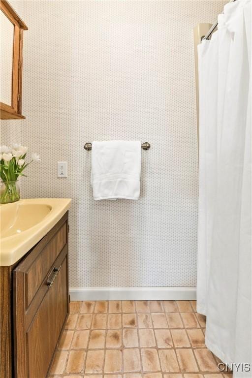 18 E Genesee St Unit 1, Skaneateles, NY 13152 - bathroom with baseboards, wallpapered walls, vanity, and a shower with shower curtain