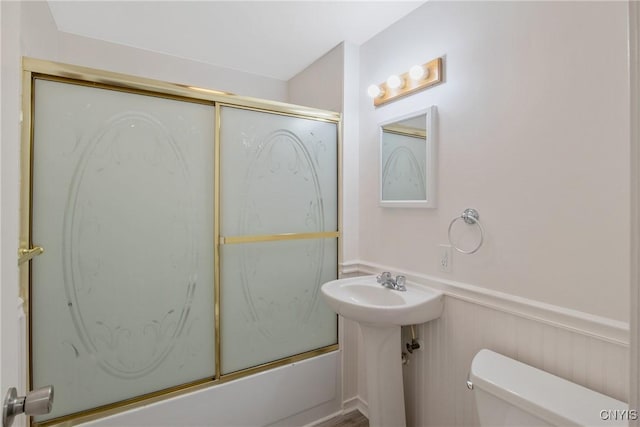 103 Pulaski St, Syracuse, NY 13204 - bathroom featuring toilet, a wainscoted wall, and shower / bath combination with glass door