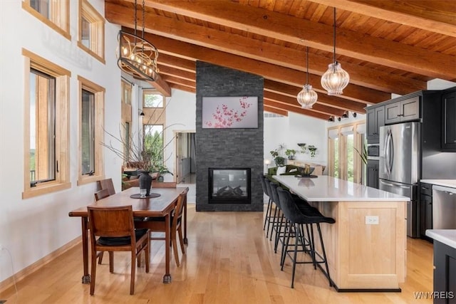 7317 Concord Rd, Concord, NY 14141 - kitchen with light countertops, appliances with stainless steel finishes, a fireplace, a center island, and a breakfast bar area