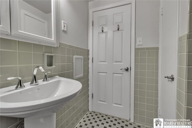 62 Thistle Ave, Tonawanda-Town, NY 14150 - bathroom with tile walls, a sink, wainscoting, and tile patterned floors