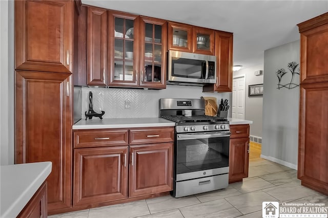 62 Thistle Ave, Tonawanda-Town, NY 14150 - kitchen with stainless steel appliances, light countertops, glass insert cabinets, and tasteful backsplash