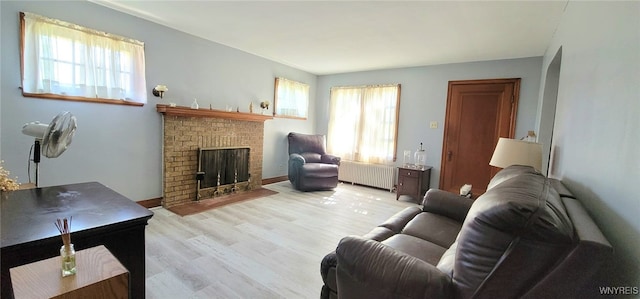 323 Portage Rd, Niagara Falls, NY 14303 - living room with radiator, plenty of natural light, wood finished floors, and a brick fireplace