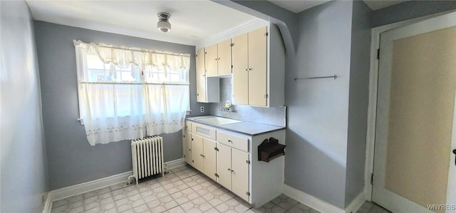 323 Portage Rd, Niagara Falls, NY 14303 - kitchen featuring radiator, a sink, baseboards, light countertops, and light flooring
