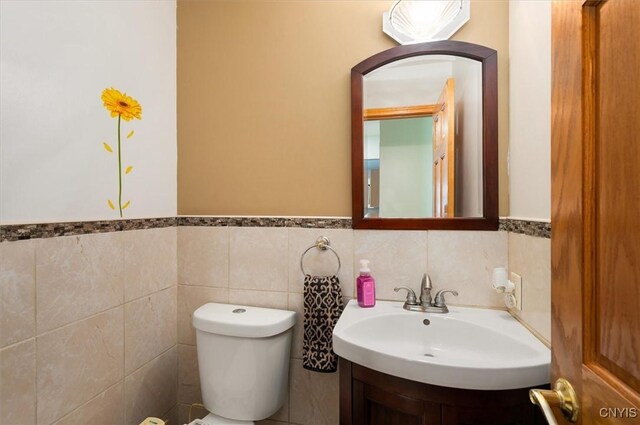 6 Viburnum Pl, New Hartford, NY 13413 - half bathroom with a sink, a wainscoted wall, toilet, and tile walls