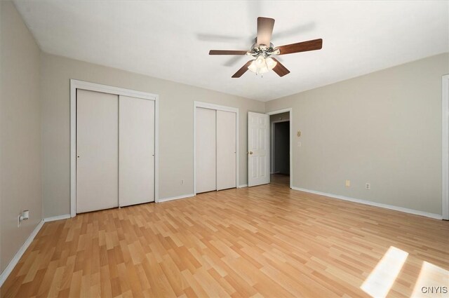 6 Viburnum Pl, New Hartford, NY 13413 - unfurnished bedroom with multiple closets, light wood-style floors, and baseboards