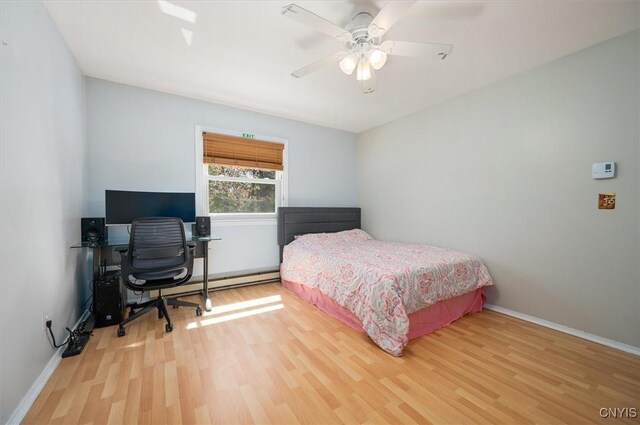 6 Viburnum Pl, New Hartford, NY 13413 - bedroom featuring wood finished floors, a desk, baseboards, a baseboard radiator, and ceiling fan