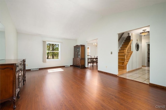 6 Viburnum Pl, New Hartford, NY 13413 - unfurnished living room with stairs, wood finished floors, a chandelier, baseboards, and vaulted ceiling