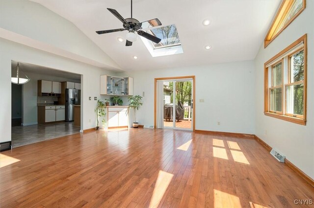 6 Viburnum Pl, New Hartford, NY 13413 - unfurnished living room featuring lofted ceiling, a skylight, light wood-style floors, a ceiling fan, and baseboards