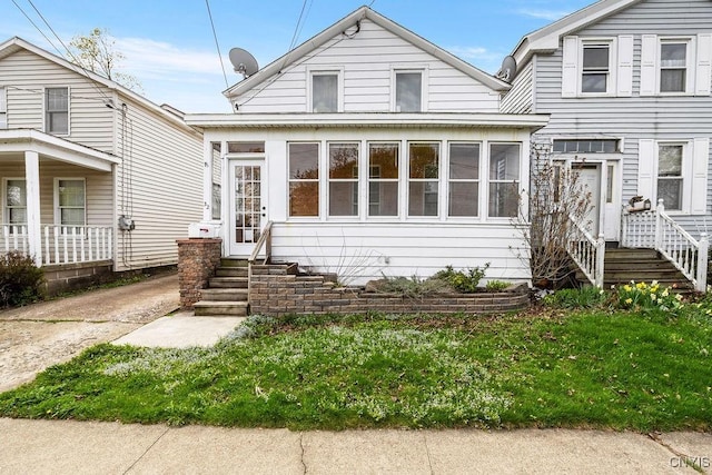 32 E 5th St, Oswego-City, NY 13126 - view of front of house with a sunroom and a front yard