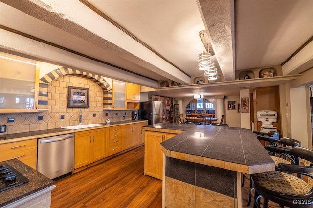 1079 State Route 49, Constantia, NY 13028 - kitchen with appliances with stainless steel finishes, a breakfast bar, dark wood-style flooring, a kitchen island, and a sink