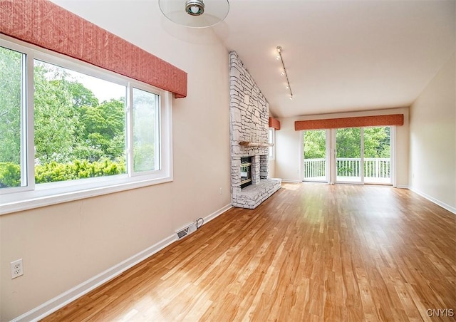 4951 Ravine Rd, Manlius, NY 13066 - unfurnished living room with hardwood / wood-style flooring, track lighting, a fireplace, and baseboards