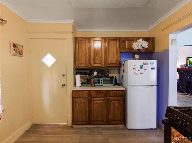 18 Rounds Ave, Buffalo, NY 14215 - kitchen featuring freestanding refrigerator, black gas stove, ornamental molding, light countertops, and wood finished floors