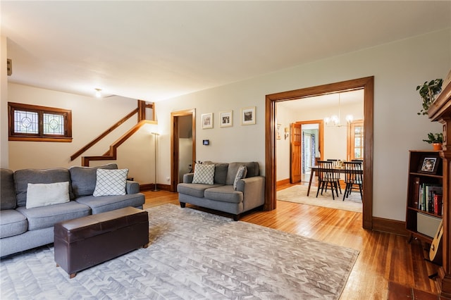 540 List Ave, Irondequoit, NY 14617 - living room with wood finished floors, a chandelier, stairway, and baseboards