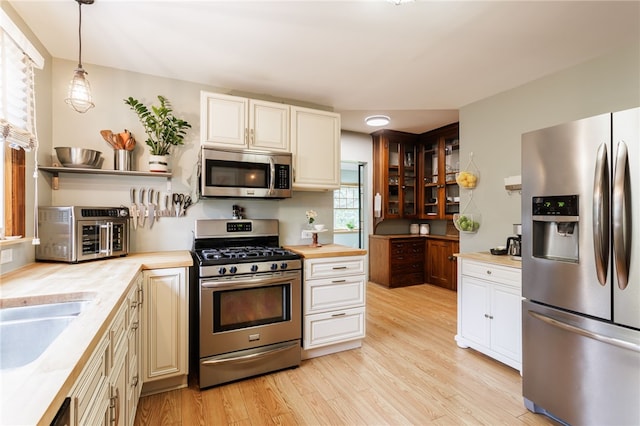540 List Ave, Irondequoit, NY 14617 - kitchen featuring stainless steel appliances, light wood-style floors, open shelves, a sink, and decorative light fixtures