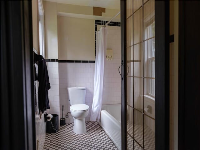 36 Pinetree Ln, Middletown, NY 12430 - full bathroom featuring tile walls, toilet, a wainscoted wall, and shower / bath combo