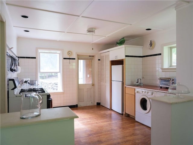 36 Pinetree Ln, Middletown, NY 12430 - kitchen featuring freestanding refrigerator, washer / clothes dryer, backsplash, light wood-style flooring, and light countertops