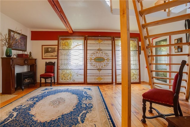 278 Taylor Rd, Jefferson, NY 12167 - entrance foyer with wood-type flooring, a wood stove, beamed ceiling, and plenty of natural light