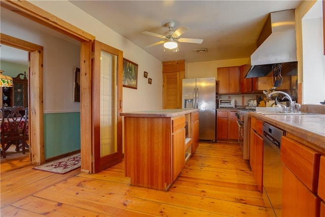 278 Taylor Rd, Jefferson, NY 12167 - kitchen with appliances with stainless steel finishes, wall chimney exhaust hood, light wood-style floors, and brown cabinets