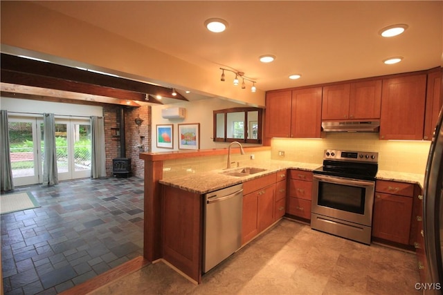 14 Fenner St, Cazenovia, NY 13035 - kitchen featuring stainless steel appliances, a sink, under cabinet range hood, a peninsula, and brown cabinetry