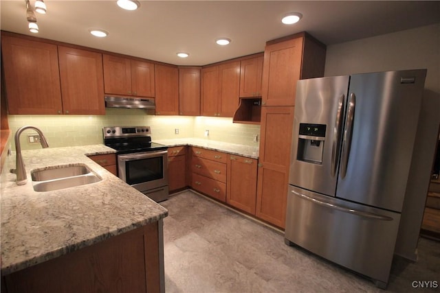 14 Fenner St, Cazenovia, NY 13035 - kitchen featuring stainless steel appliances, a sink, under cabinet range hood, brown cabinetry, and light stone counters