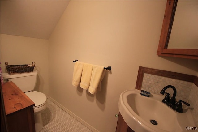 14 Fenner St, Cazenovia, NY 13035 - bathroom featuring a sink, toilet, lofted ceiling, baseboards, and tile patterned flooring