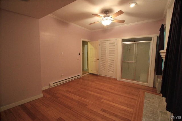 14 Fenner St, Cazenovia, NY 13035 - unfurnished bedroom featuring a baseboard radiator, wood finished floors, baseboards, crown molding, and a closet