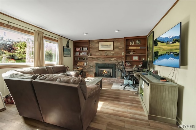 591 Girdle Rd, Elma, NY 14052 - living room with built in shelves, a brick fireplace, and light wood-style flooring