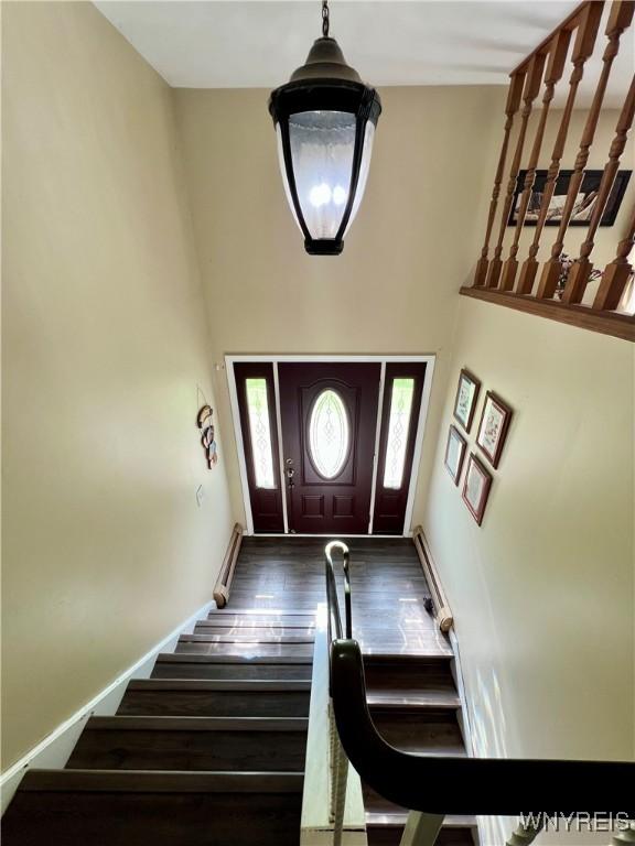 591 Girdle Rd, Elma, NY 14052 - entrance foyer with stairway, wood finished floors, a towering ceiling, and baseboards