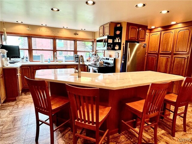 9A Lina St, Morristown, NY 13669 - kitchen featuring stainless steel appliances, a sink, recessed lighting, an island with sink, and a breakfast bar