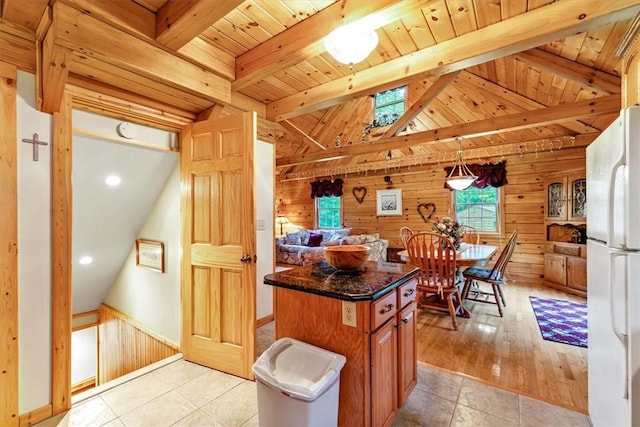 1311 Snake Creek Rd, Hancock, NY 13783 - kitchen with freestanding refrigerator, wooden walls, dark stone countertops, wooden ceiling, and light tile patterned floors
