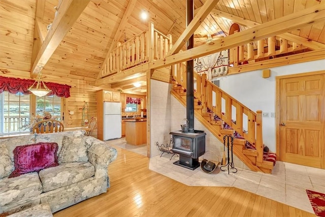 1311 Snake Creek Rd, Hancock, NY 13783 - living room featuring high vaulted ceiling, wooden ceiling with exposed beams, stairway, light wood-style floors, and a wood stove