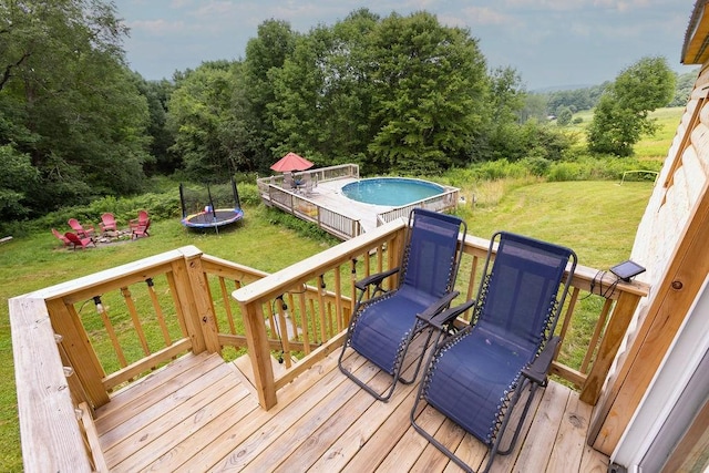 2165 Hamden Hill Rd, Hamden, NY 13782 - wooden deck with a trampoline, a lawn, an outdoor pool, and a view of trees