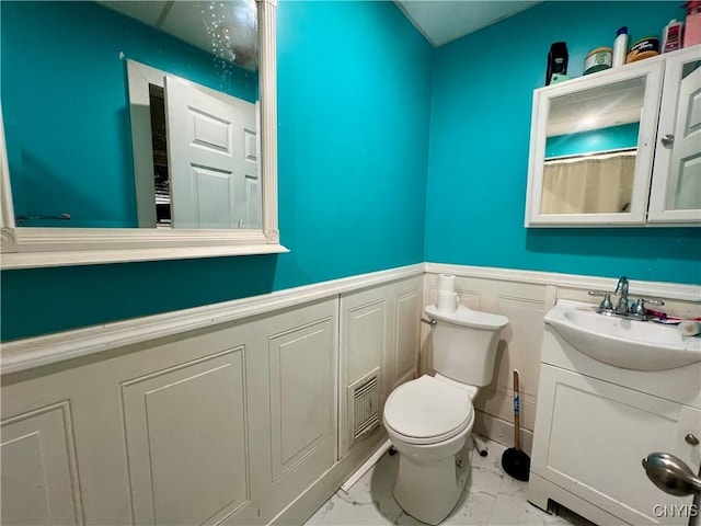 1703 Whitesboro St, Utica, NY 13502 - bathroom with marble finish flooring, vanity, wainscoting, and toilet