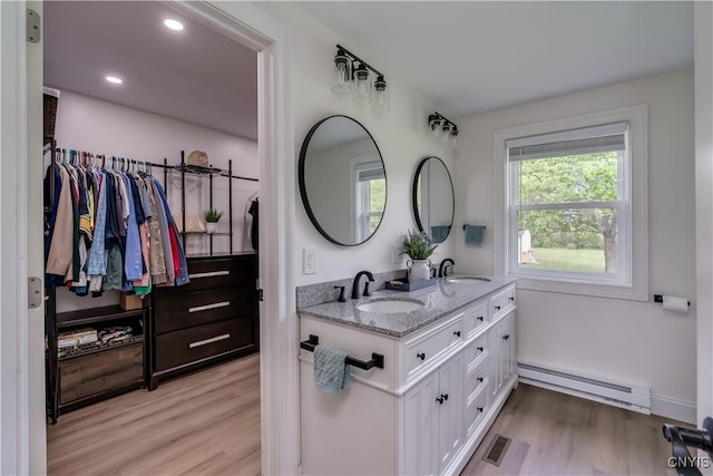 436 Centre St, Cape Vincent, NY 13618 - full bath featuring a baseboard radiator, double vanity, wood finished floors, recessed lighting, and a walk in closet