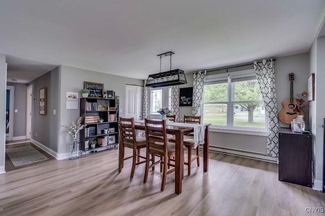 436 Centre St, Cape Vincent, NY 13618 - dining space with baseboard heating, wood finished floors, and baseboards