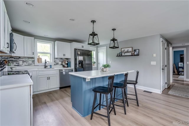 436 Centre St, Cape Vincent, NY 13618 - kitchen featuring stainless steel appliances, a sink, light wood finished floors, decorative backsplash, and light countertops