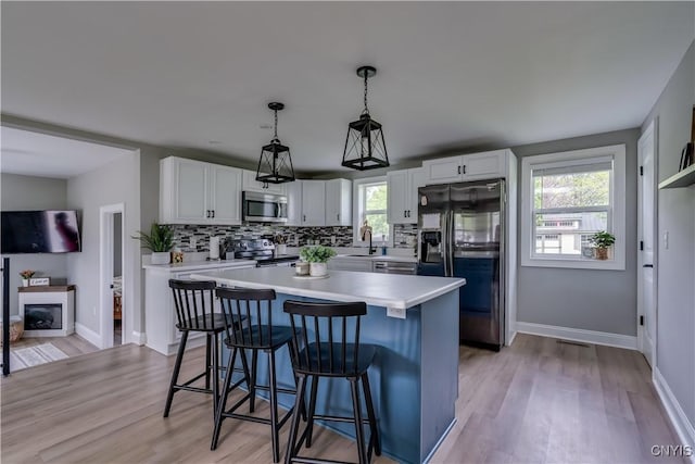 436 Centre St, Cape Vincent, NY 13618 - kitchen with stainless steel appliances, a kitchen bar, light countertops, and white cabinets