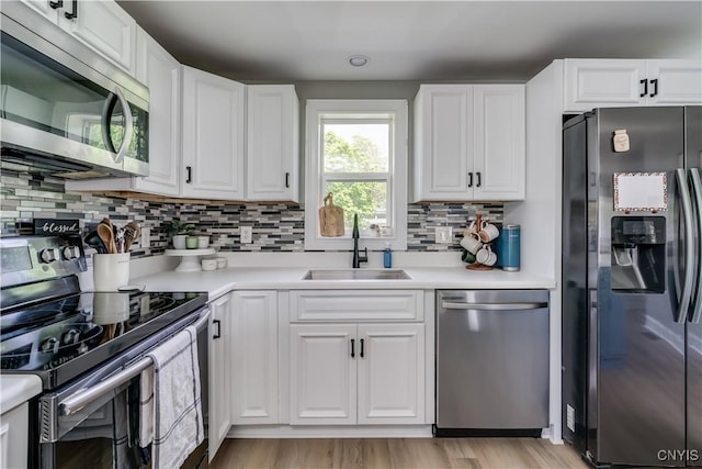 436 Centre St, Cape Vincent, NY 13618 - kitchen with stainless steel appliances, a sink, tasteful backsplash, light countertops, and white cabinetry