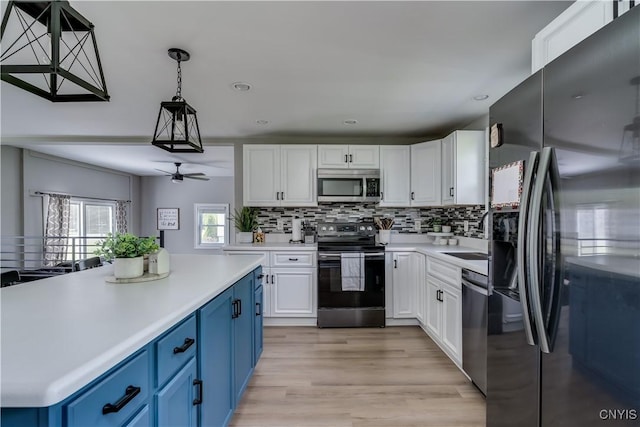 436 Centre St, Cape Vincent, NY 13618 - kitchen with stainless steel appliances, blue cabinets, white cabinetry, light countertops, and recessed lighting