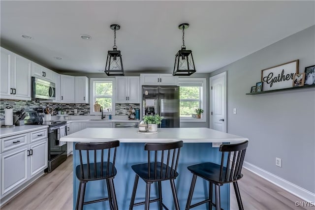 436 Centre St, Cape Vincent, NY 13618 - kitchen with stainless steel appliances, backsplash, light countertops, white cabinets, and a sink