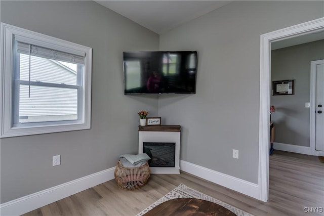 436 Centre St, Cape Vincent, NY 13618 - living area featuring wood finished floors, lofted ceiling, baseboards, and a glass covered fireplace