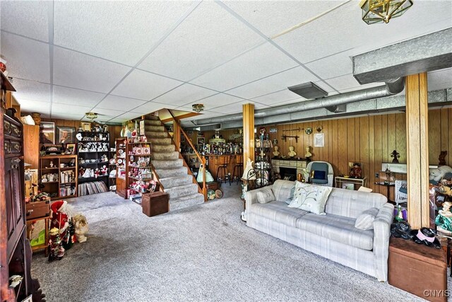 829 Franklin St, Skaneateles, NY 13152 - carpeted living room with a drop ceiling, stairs, and wooden walls