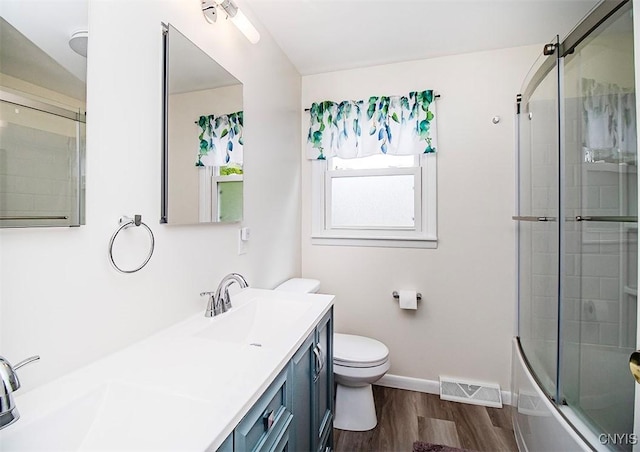 106 Peterson Dr, Camillus, NY 13031 - bathroom with wood finished floors, double vanity, toilet, baseboards, and bath / shower combo with glass door