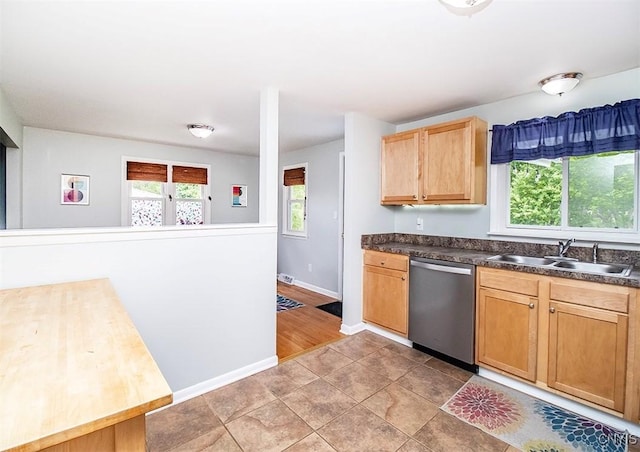 106 Peterson Dr, Camillus, NY 13031 - kitchen featuring stainless steel dishwasher, a sink, dark countertops, baseboards, and light brown cabinets