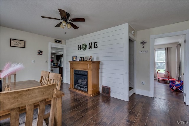 44191 Lime St, Wilna, NY 13665 - dining space with a ceiling fan, a fireplace, dark wood finished floors, a textured ceiling, and baseboards