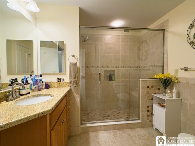 50 Lakeside Dr Unit C103, Ellery, NY 14712 - bathroom featuring vanity, a stall shower, tile walls, toilet, and tile patterned flooring