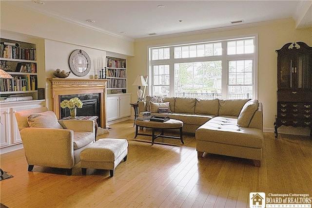 50 Lakeside Dr Unit C103, Ellery, NY 14712 - living area featuring ornamental molding, a glass covered fireplace, built in features, and light wood-style flooring