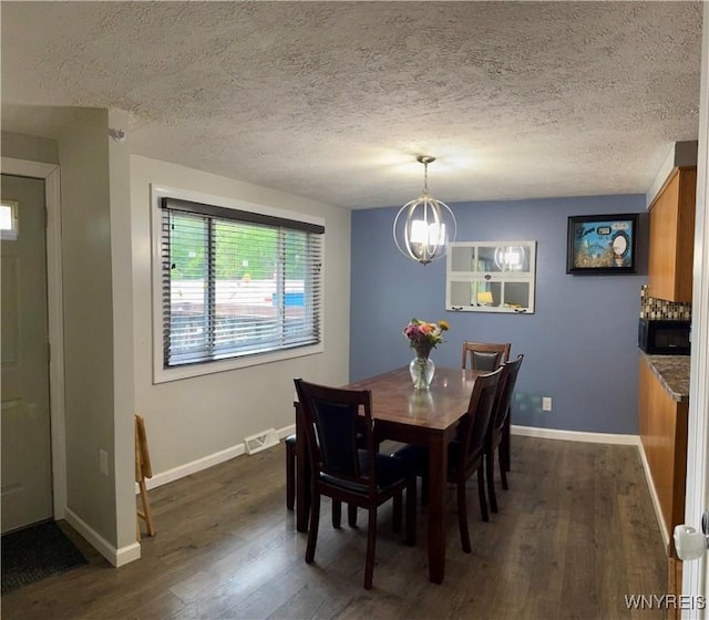 9357 Steffi Dr, Evans, NY 14006 - dining space with dark wood-style floors, baseboards, a chandelier, and a textured ceiling